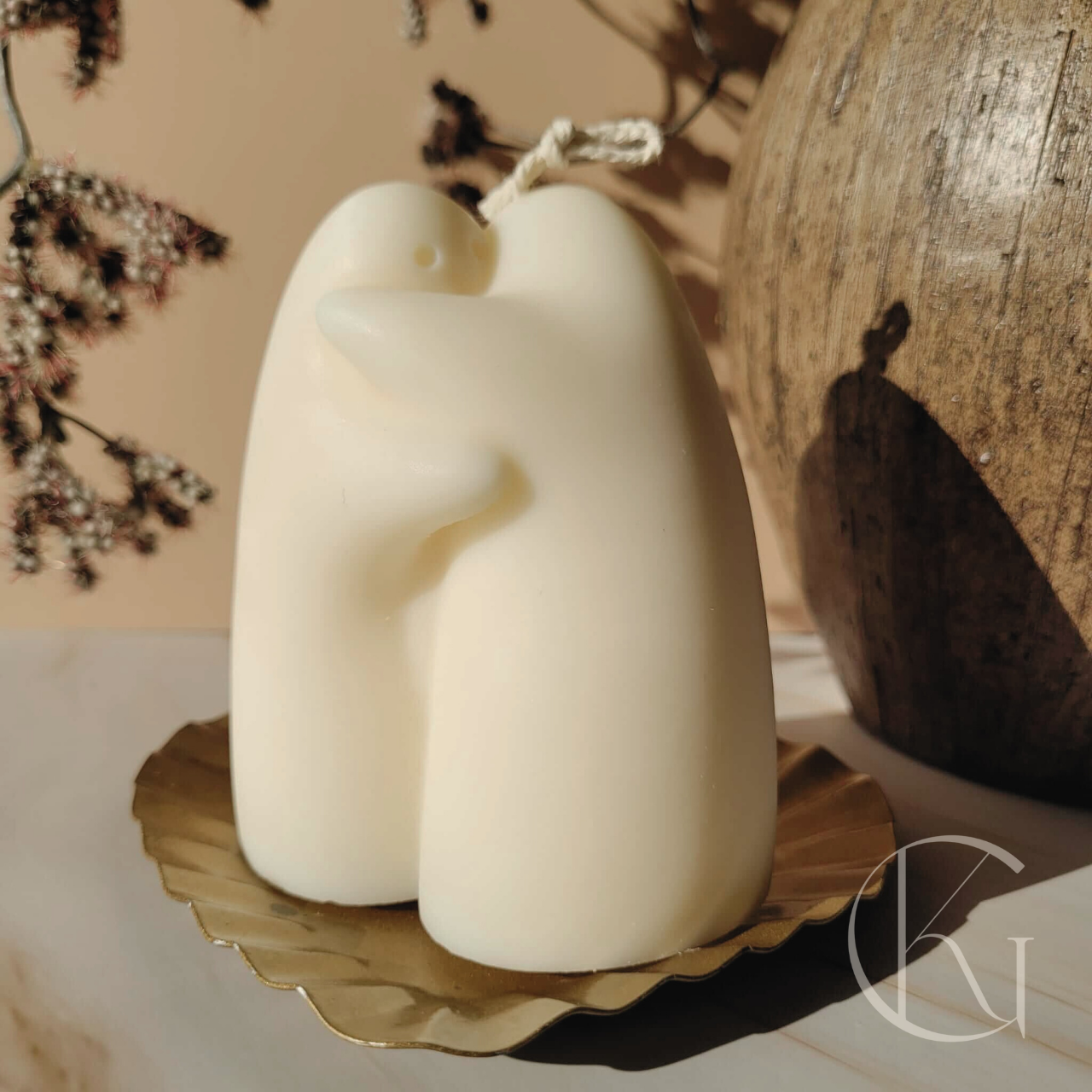 handgemaakte kaars van sojawas in de vorm van twee figuren die elkaar een knuffel geven