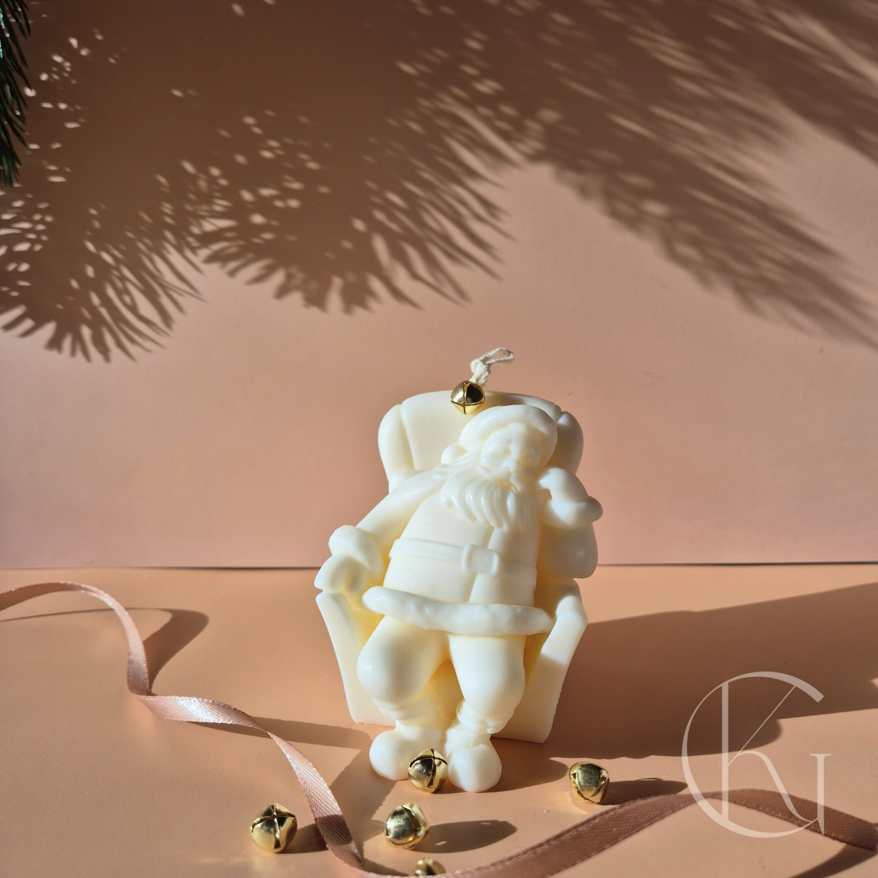 Handgemaakte kaars van slapende kerstman in stoel, geurloos en duurzaam, perfect voor kerstdecoratie.