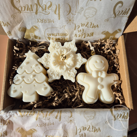 Kerstbox met drie handgemaakte kaarsjes van geurloze sojawas: sneeuwvlok, peperkoekman en kerstboom. Feestelijke kerstdecoratie en cadeau.